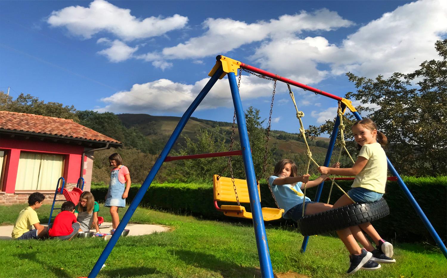 Groupe d’enfants jouant dans le jardin d’une maison rurale.